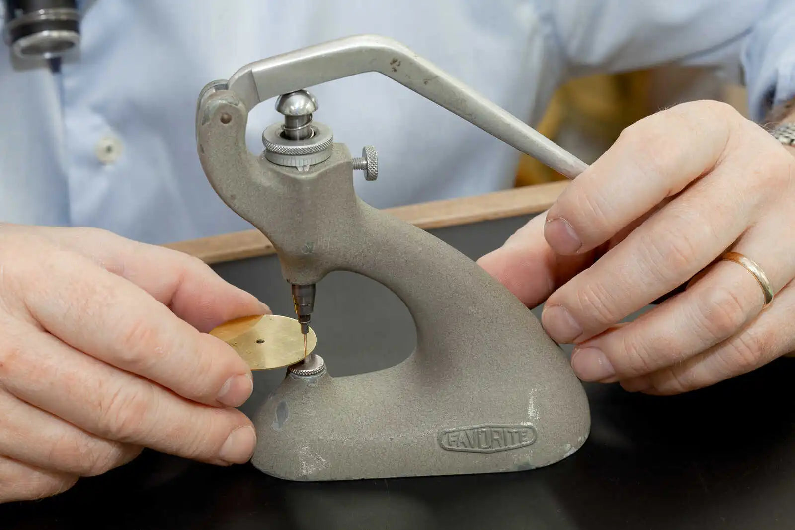 Riviting feet onto a brass dial blank in the garrick workshop
