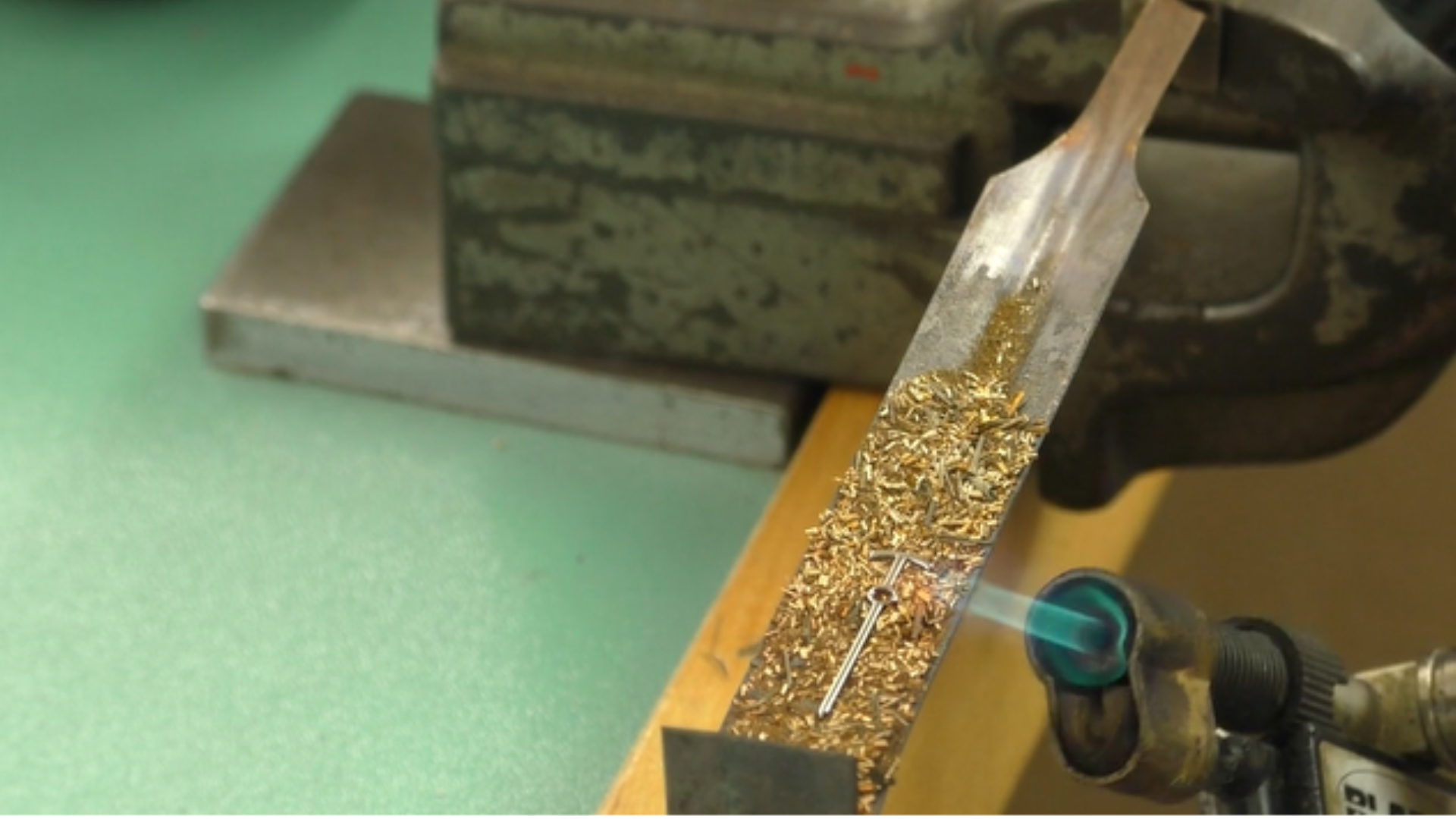Turning steel watch hands blue using copper filings and a flame in the garrick workshop